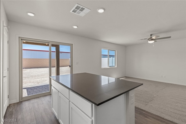 kitchen featuring ceiling fan, plenty of natural light, white cabinets, and hardwood / wood-style flooring