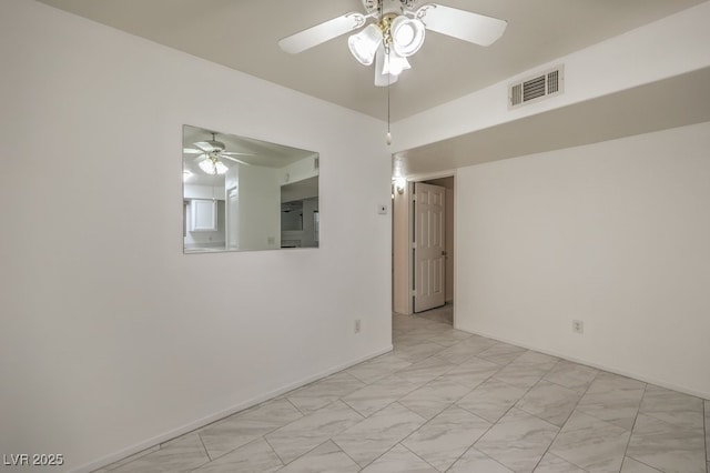 empty room featuring ceiling fan, marble finish floor, visible vents, and baseboards