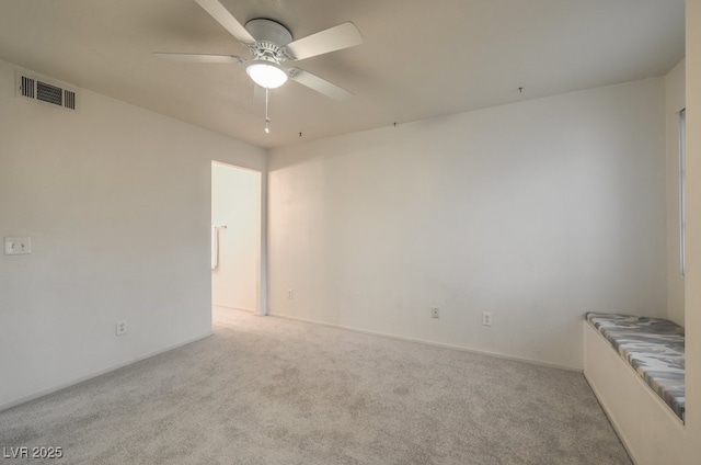 empty room with ceiling fan, carpet flooring, and visible vents