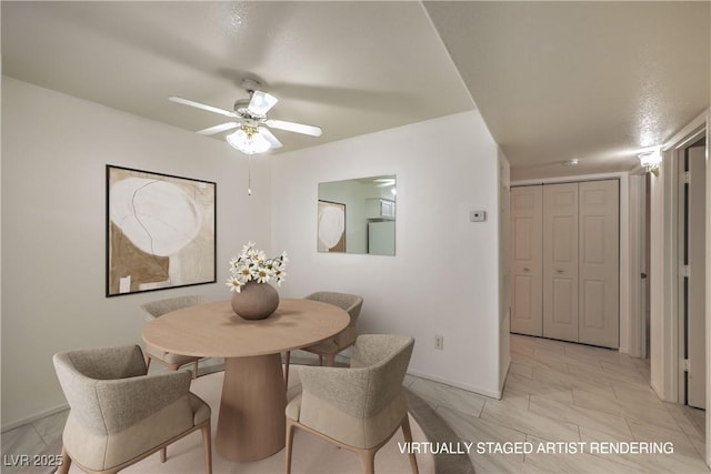 dining space featuring ceiling fan and baseboards