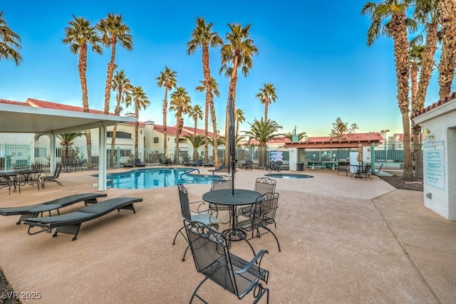 pool featuring a patio area, a hot tub, and fence