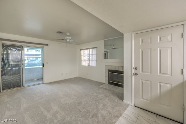 unfurnished living room featuring ceiling fan, a fireplace, visible vents, and carpet flooring