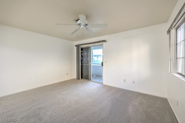 carpeted empty room with a ceiling fan and baseboards