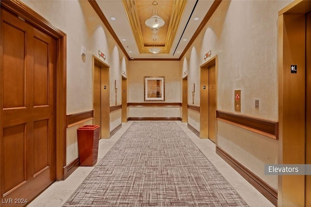 hallway featuring elevator, crown molding, a high ceiling, and a tray ceiling