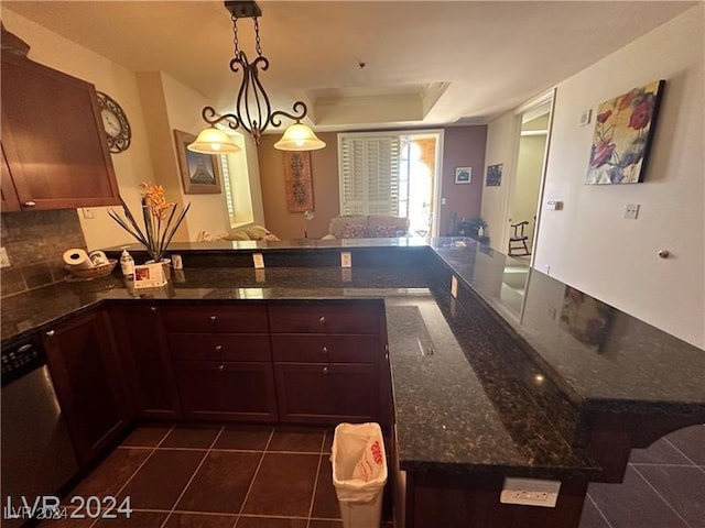 kitchen with kitchen peninsula, dark tile patterned floors, pendant lighting, dark stone countertops, and dishwasher