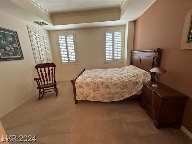 bedroom with carpet, a tray ceiling, and ornamental molding