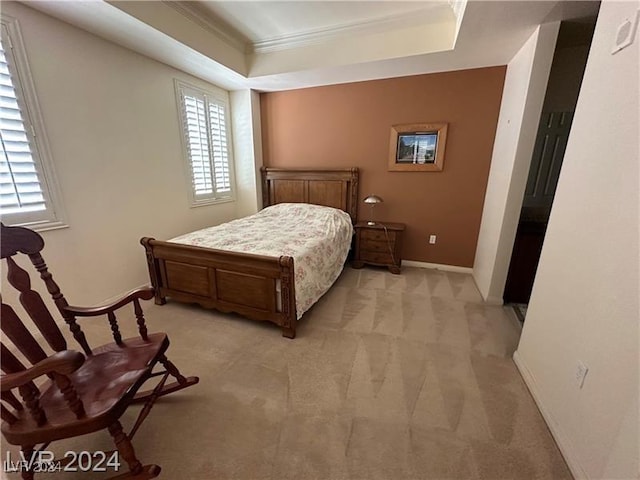 carpeted bedroom featuring ornamental molding and a tray ceiling