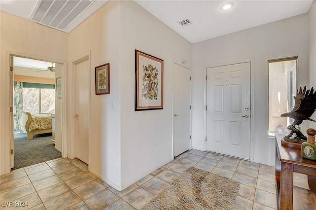 foyer with light tile patterned floors and ceiling fan