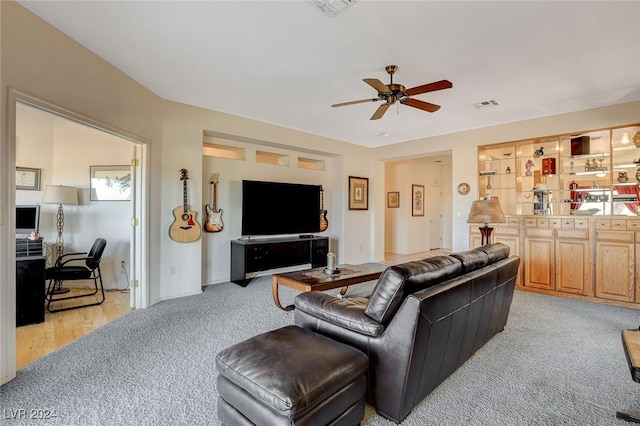 carpeted living room with ceiling fan