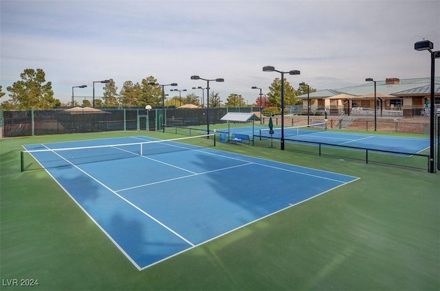 view of tennis court featuring basketball hoop