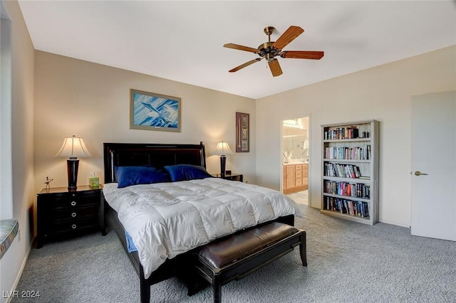 bedroom featuring ceiling fan, light colored carpet, and ensuite bath