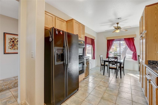 kitchen with light brown cabinets, dark stone counters, black appliances, ceiling fan, and light tile patterned floors