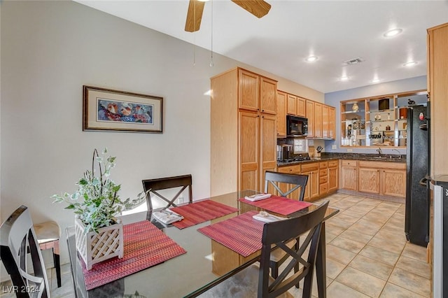 dining space featuring ceiling fan, light tile patterned floors, and sink