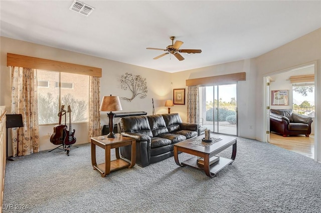 carpeted living room with ceiling fan