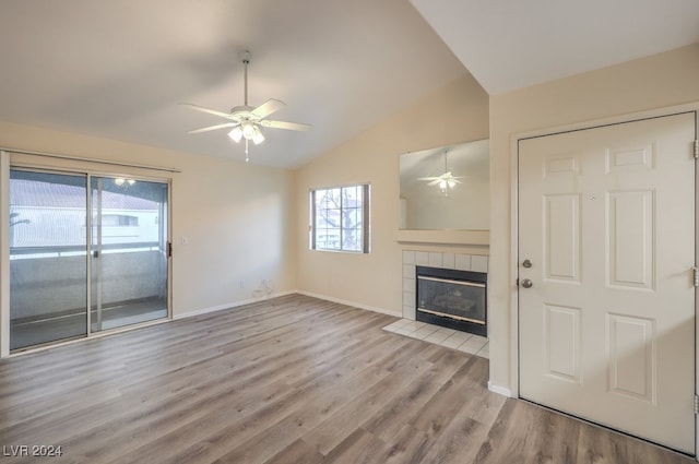 unfurnished living room featuring lofted ceiling, a fireplace, light hardwood / wood-style floors, and ceiling fan