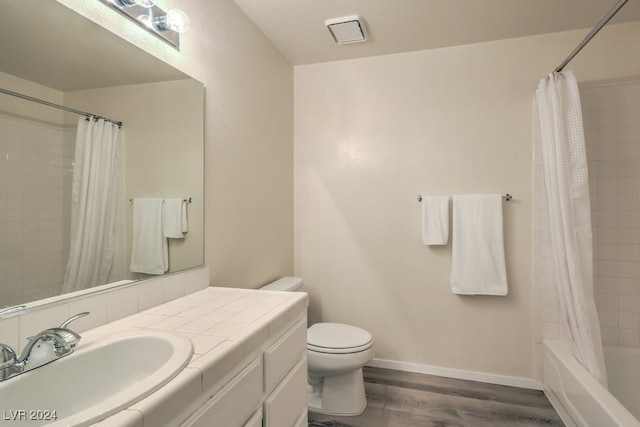 full bathroom with shower / bathtub combination with curtain, wood-type flooring, toilet, and vanity