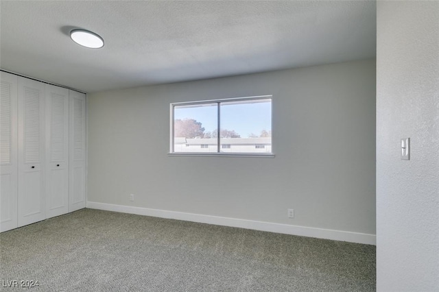 unfurnished bedroom with carpet, a textured ceiling, and a closet