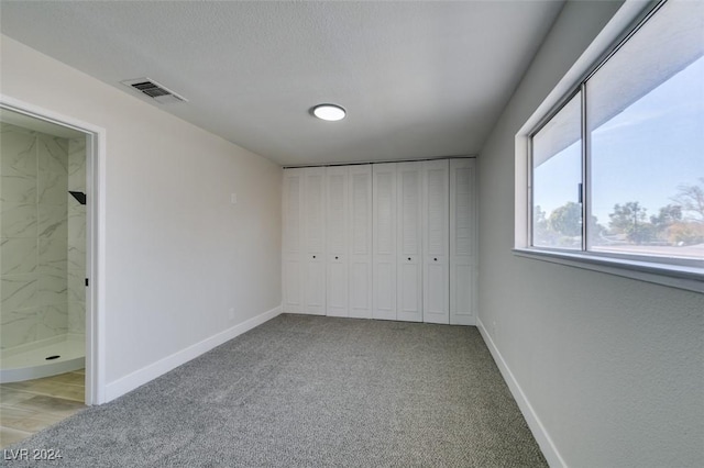 unfurnished bedroom featuring light carpet and a closet