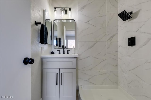 bathroom with tiled shower and vanity