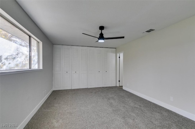 unfurnished bedroom with carpet flooring, ceiling fan, and a closet