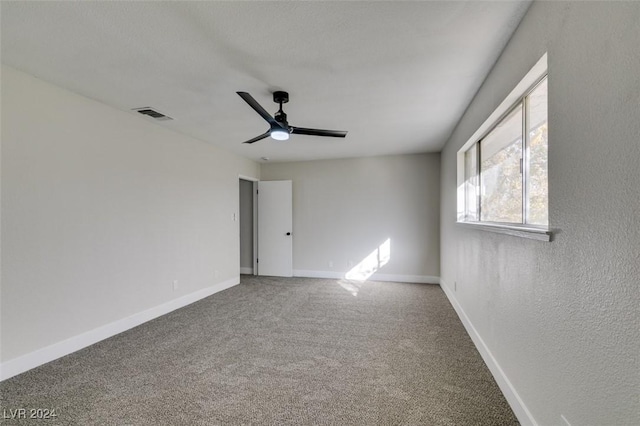 carpeted spare room with ceiling fan