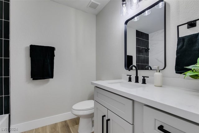 bathroom featuring wood-type flooring, vanity, and toilet