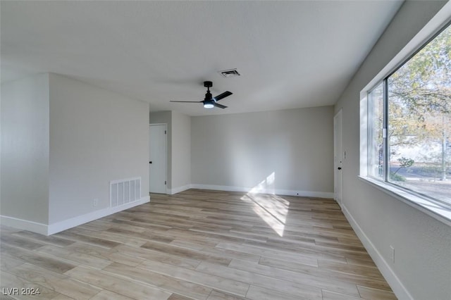 empty room featuring light hardwood / wood-style floors, ceiling fan, and a healthy amount of sunlight