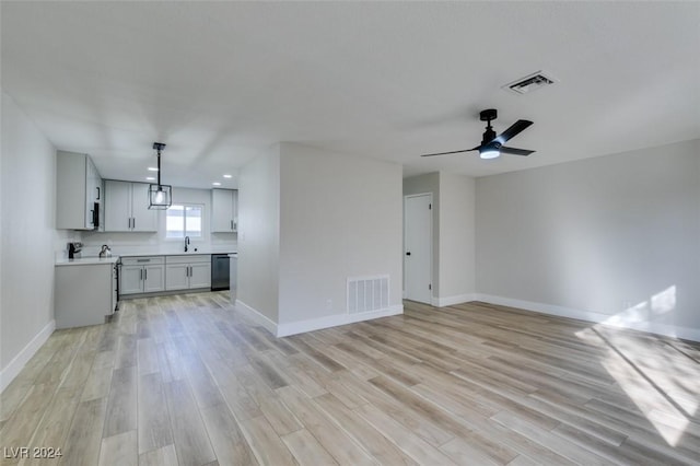 unfurnished living room featuring ceiling fan, light wood-type flooring, and sink