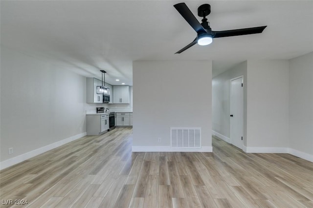 unfurnished living room featuring ceiling fan and light hardwood / wood-style floors