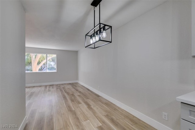 interior space featuring light wood-type flooring and an inviting chandelier