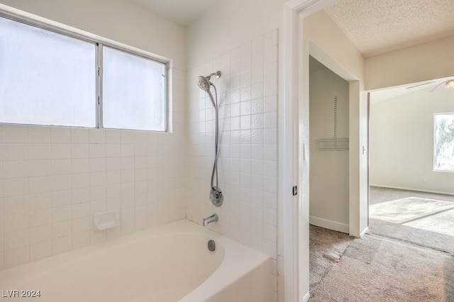 bathroom with tiled shower / bath combo, plenty of natural light, and ceiling fan