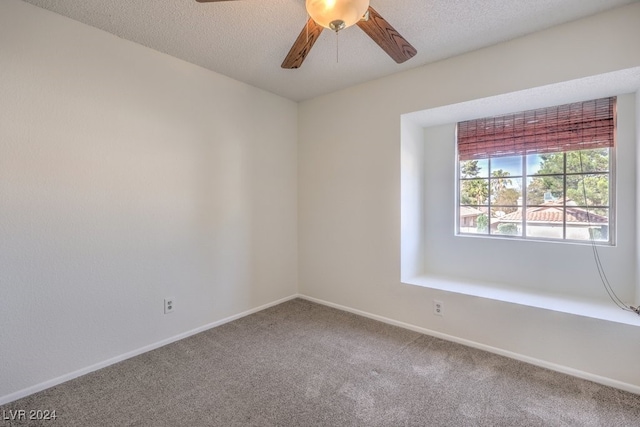 carpeted empty room with ceiling fan and a textured ceiling