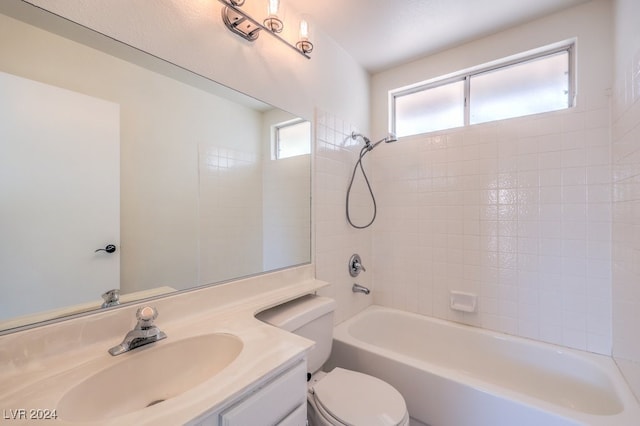 full bathroom featuring vanity, tiled shower / bath combo, and toilet