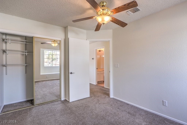 unfurnished bedroom with carpet flooring, a textured ceiling, a closet, and ceiling fan