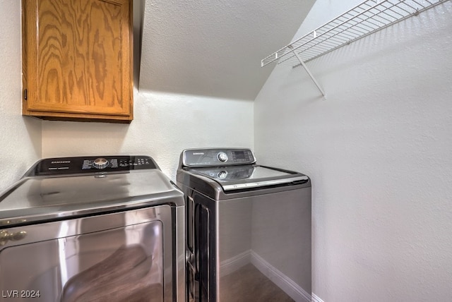 clothes washing area with washer and clothes dryer and cabinets