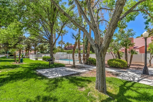 view of community featuring a lawn and a swimming pool