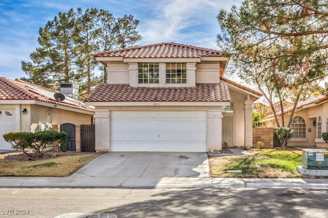 mediterranean / spanish home with a garage and central AC unit