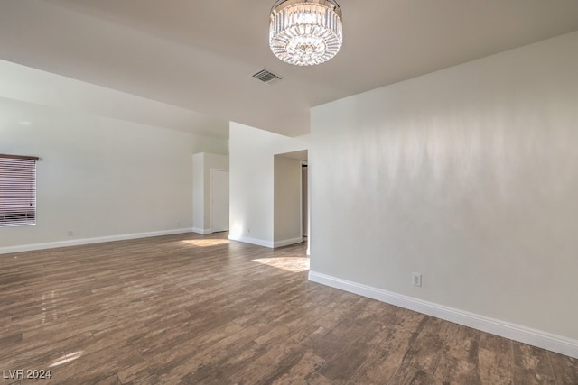 unfurnished room with dark hardwood / wood-style flooring and a chandelier