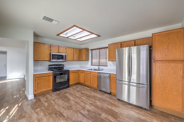 kitchen with wood-type flooring, stainless steel appliances, and sink