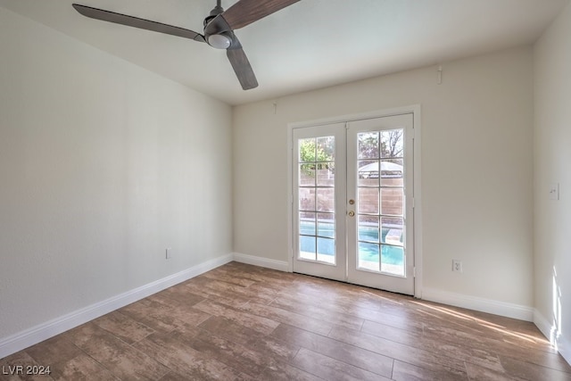 spare room with hardwood / wood-style flooring, ceiling fan, and french doors