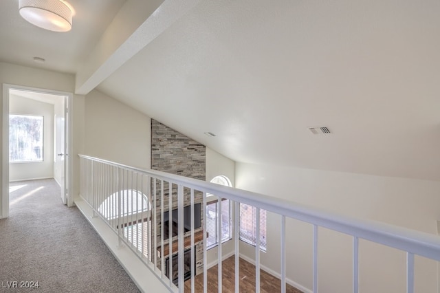 hall featuring carpet flooring and vaulted ceiling