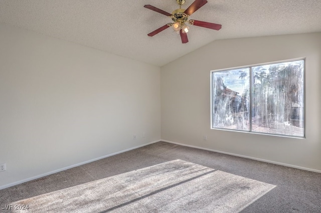 spare room featuring a textured ceiling, ceiling fan, light carpet, and vaulted ceiling