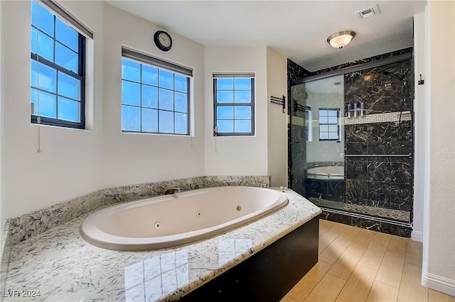 bathroom with separate shower and tub and wood-type flooring