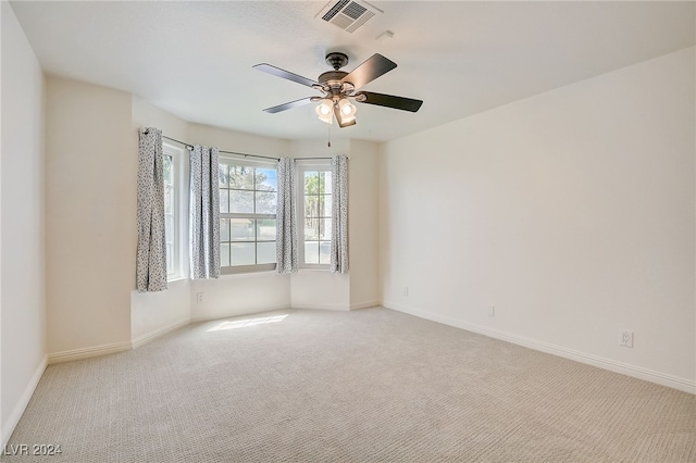 carpeted spare room with ceiling fan