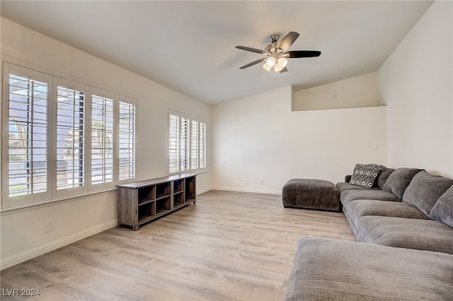 living room featuring ceiling fan, light hardwood / wood-style floors, and vaulted ceiling