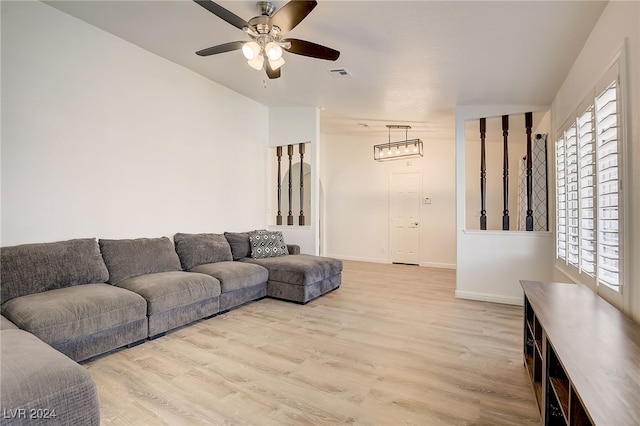 living room featuring ceiling fan, light wood-type flooring, and a wealth of natural light