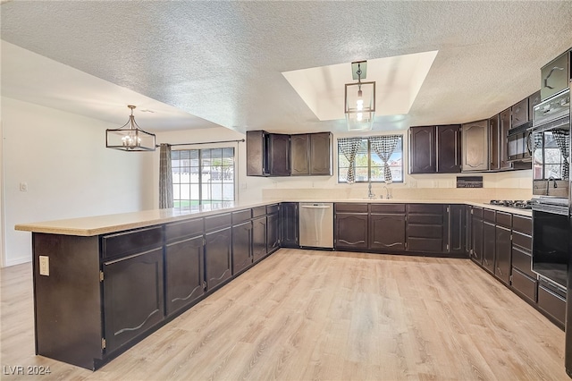 kitchen featuring kitchen peninsula, plenty of natural light, light hardwood / wood-style floors, and decorative light fixtures