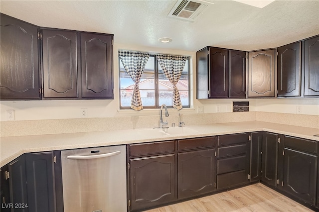 kitchen featuring dishwasher, a textured ceiling, light wood-type flooring, and dark brown cabinetry