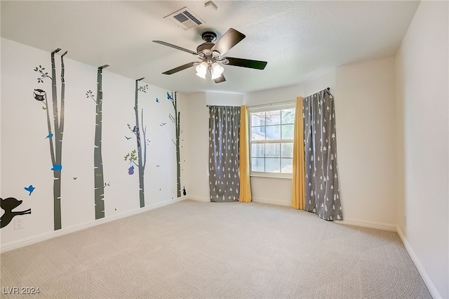 empty room featuring ceiling fan and light colored carpet