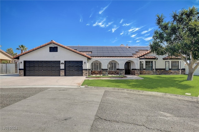 view of front of home with solar panels, a garage, and a front lawn